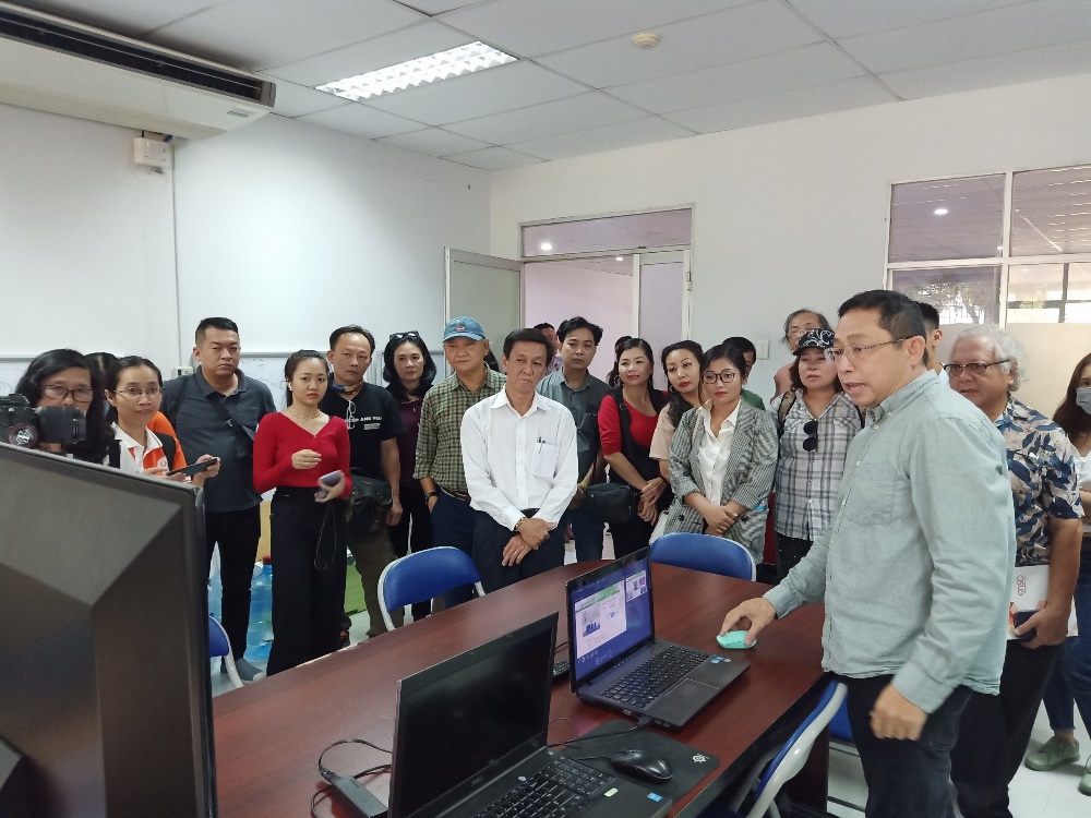 Dr. Nguyen Dinh Uyen (R) introduced the technology to detect fake wine to Deputy Head of the Department of Propaganda and Training of the HCMC Party Committee, Nguyen Tho Truyen (white shirt) and the delegation