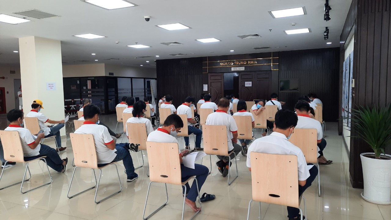 Các nhân viên ngồi giãn cách 2m chờ đến lượt được tiêm