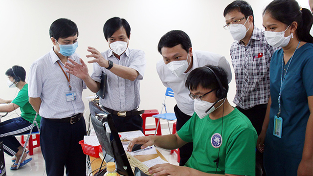 Deputy Minister of Information and Communications Nguyen Huy Dung (white shirt in the middle) is listening to the introduction of working procedure of 115 Emergency Center at QTSC