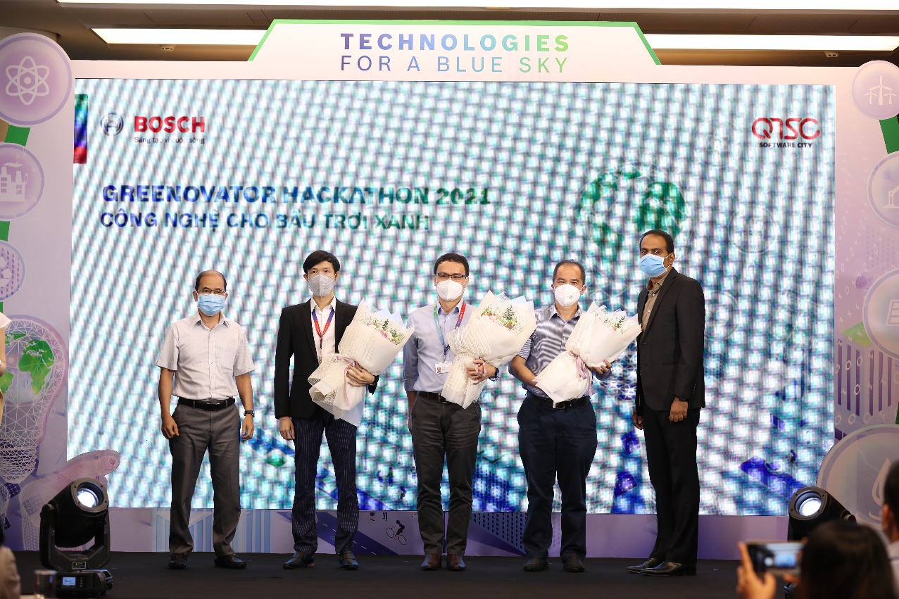 Hình 2: Ông Vũ Quang – Phó Giám đốc QTSC (bìa trái) và ông Guru Mallikarjuna, Tổng giám đốc Bosch Việt Nam (bìa phải) tặng hoa tri ân ban giám khảo cuộc thi