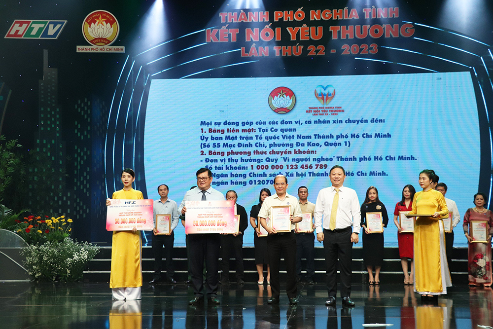 Phó Chủ tịch UBND TP.HCM Dương Anh Đức (bên phải) và Phó Chủ tịch Ủy ban MTTQ Việt Nam TP.HCM Ngô Thanh Sơn (bên trái) nhân bảng tượng trưng từ ông Vũ Quang – Phó Giám đốc điều hành QTSC (đứng giữa)