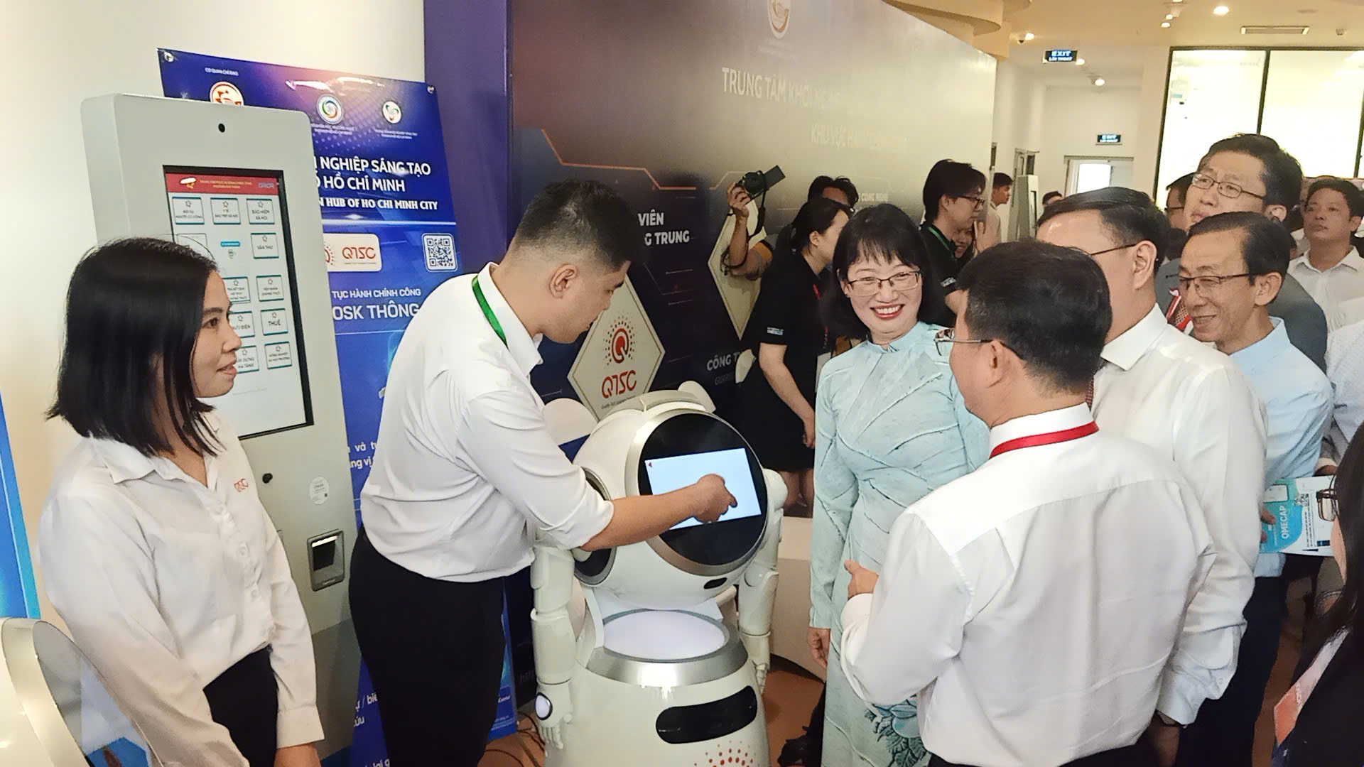 Đại biểu tham quan khu vực trưng bày Giải pháp thủ tục hành chính công Robot AI và Kiosk thông minh của QTSC